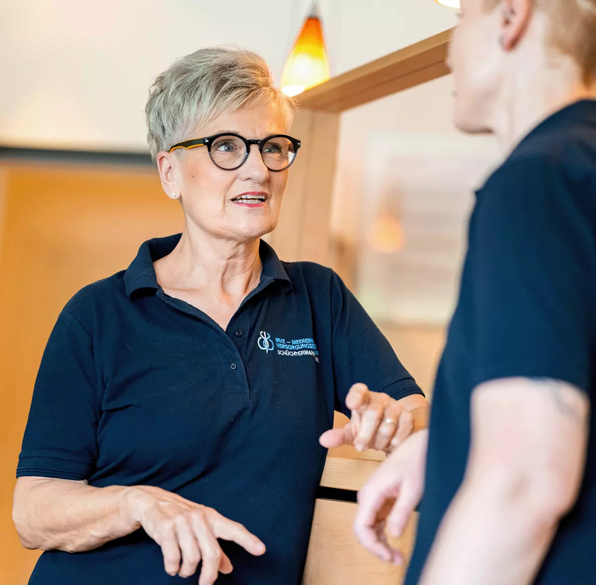 Zwei Mitarbeitende der Psychotherapie-Abteilung besprechen sich am Empfang, um sicherzustellen, dass jeder Patient individuell und professionell betreut wird.
