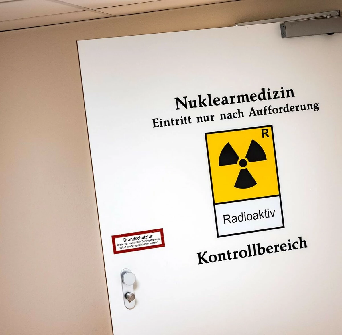 Eine Tür mit der Aufschrift Nuklearmedizin, Eintritt nur nach Aufforderung ist zu sehen