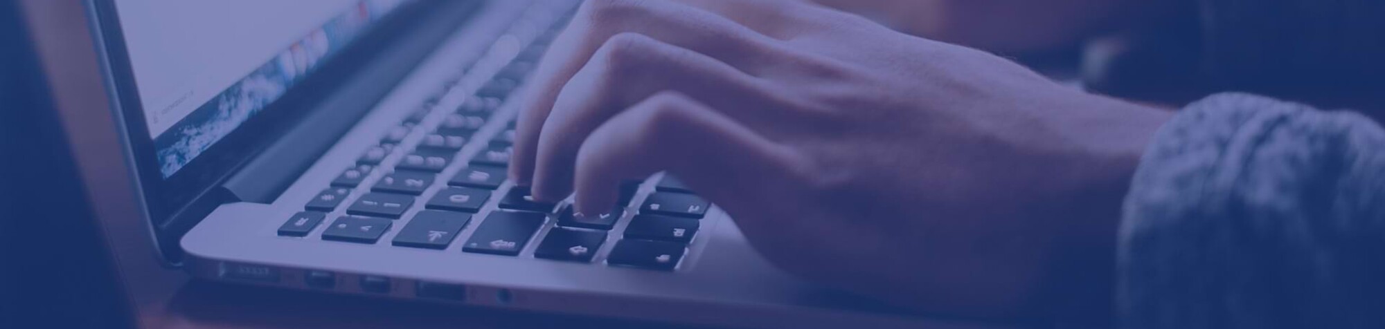 Nahaufnahme einer Person, die auf der Tastatur eines Notebooks tippt