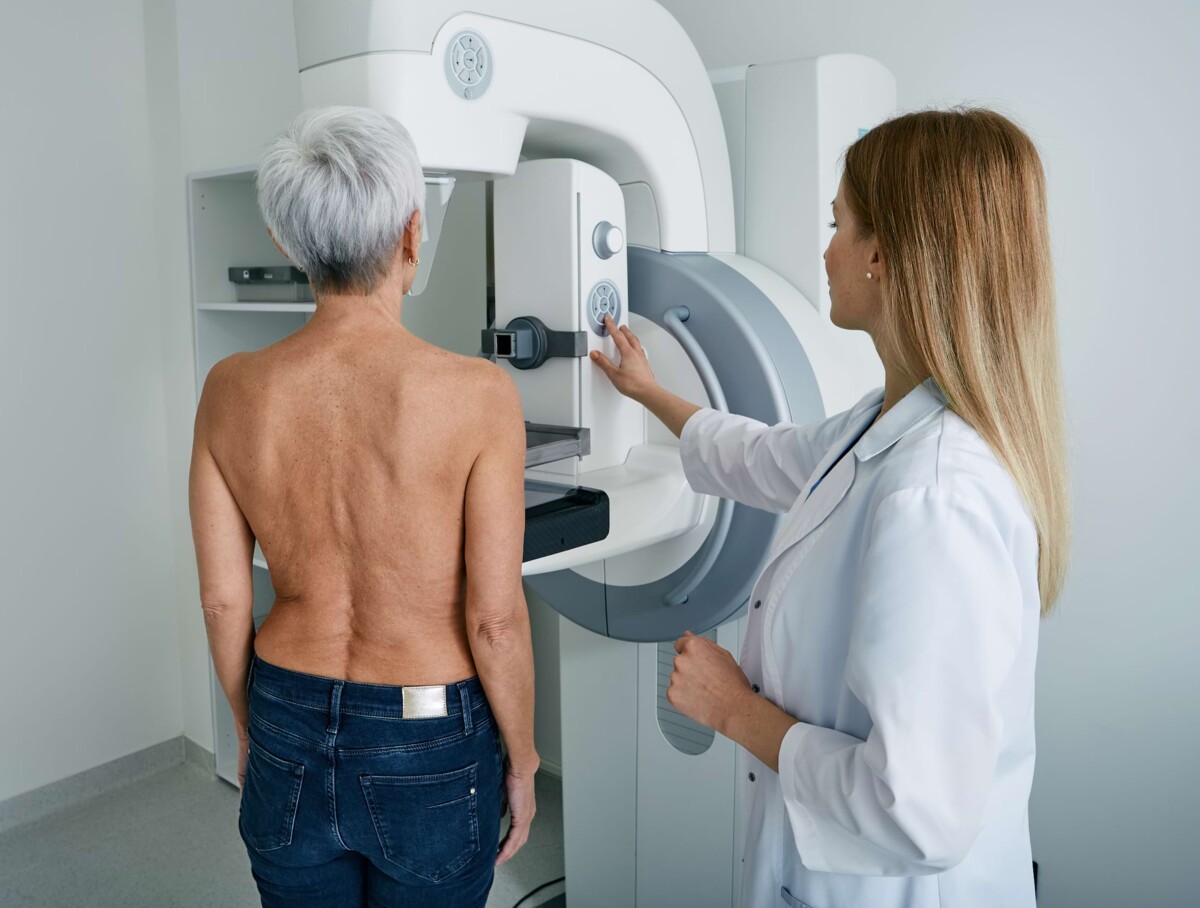 Eine Patientin wird für eine Röntgenaufnahme ausgerichtet und betreut, während die Mitarbeiterin sicherstellt, dass die Untersuchung schnell und präzise durchgeführt wird.