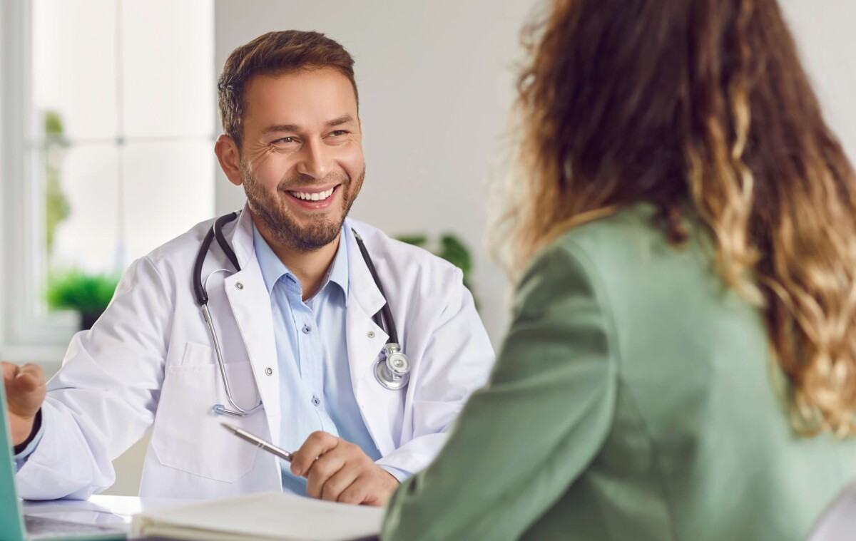 Ein Arzt erklärt einer Patientin wir Telemonitoring funktioniert und welche Vorteile es hat