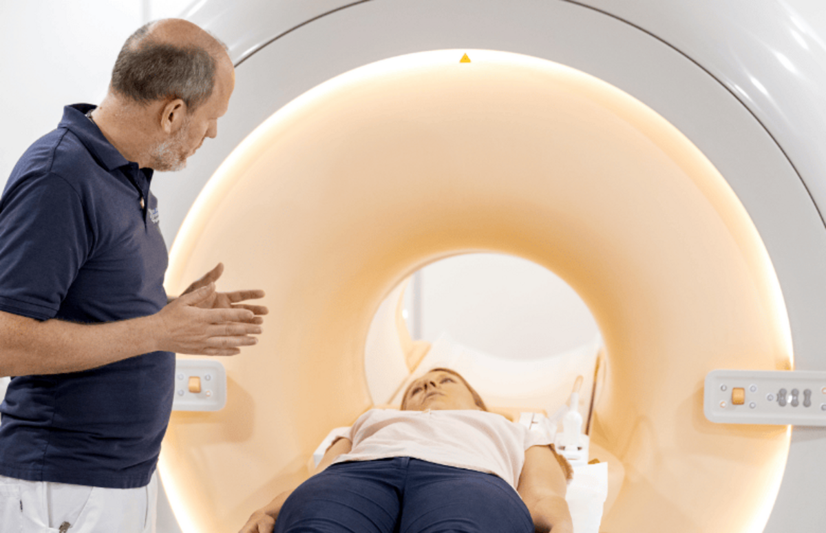 Ein Mitarbeiter erklärt einem Patienten die Untersuchung im MRT, während die moderne Technologie der Schüchtermann-Klinik zum Einsatz kommt